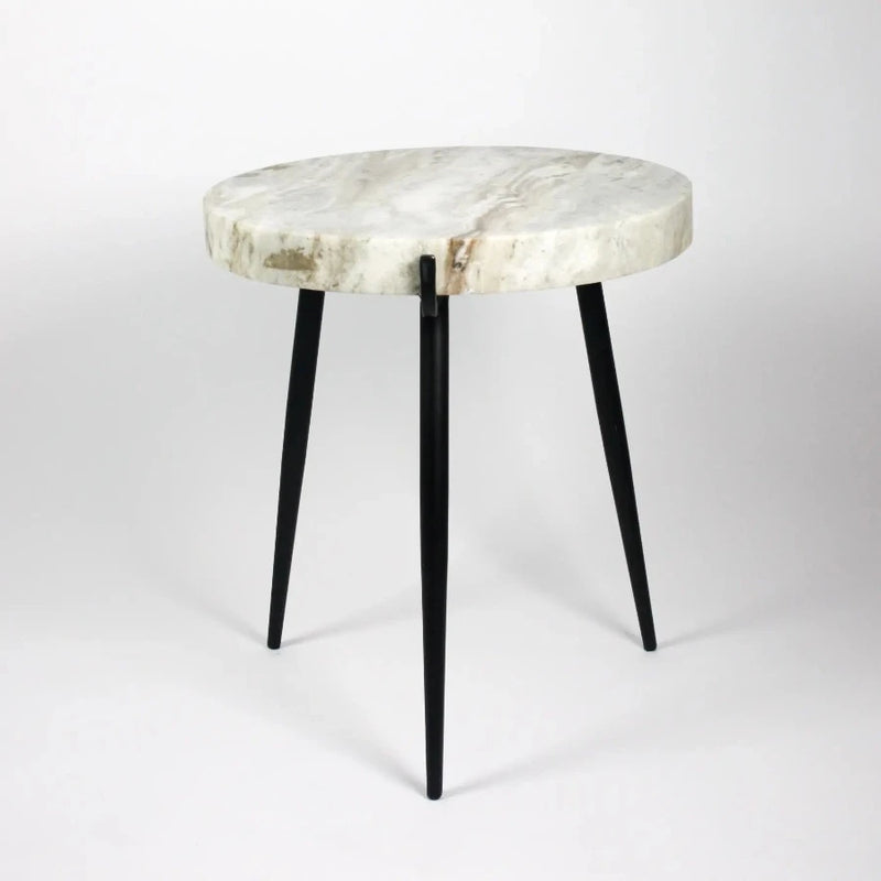 side view of the white marble side table with its 3 legs in black iron from swedish design studio olsson and jenssen