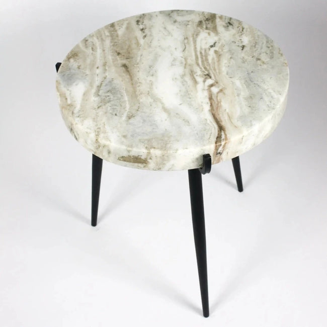 three, black iron legged, side table with a highly polished veined white grey marble with streaks of browns and golden hazes from swedish design house olson and jensen