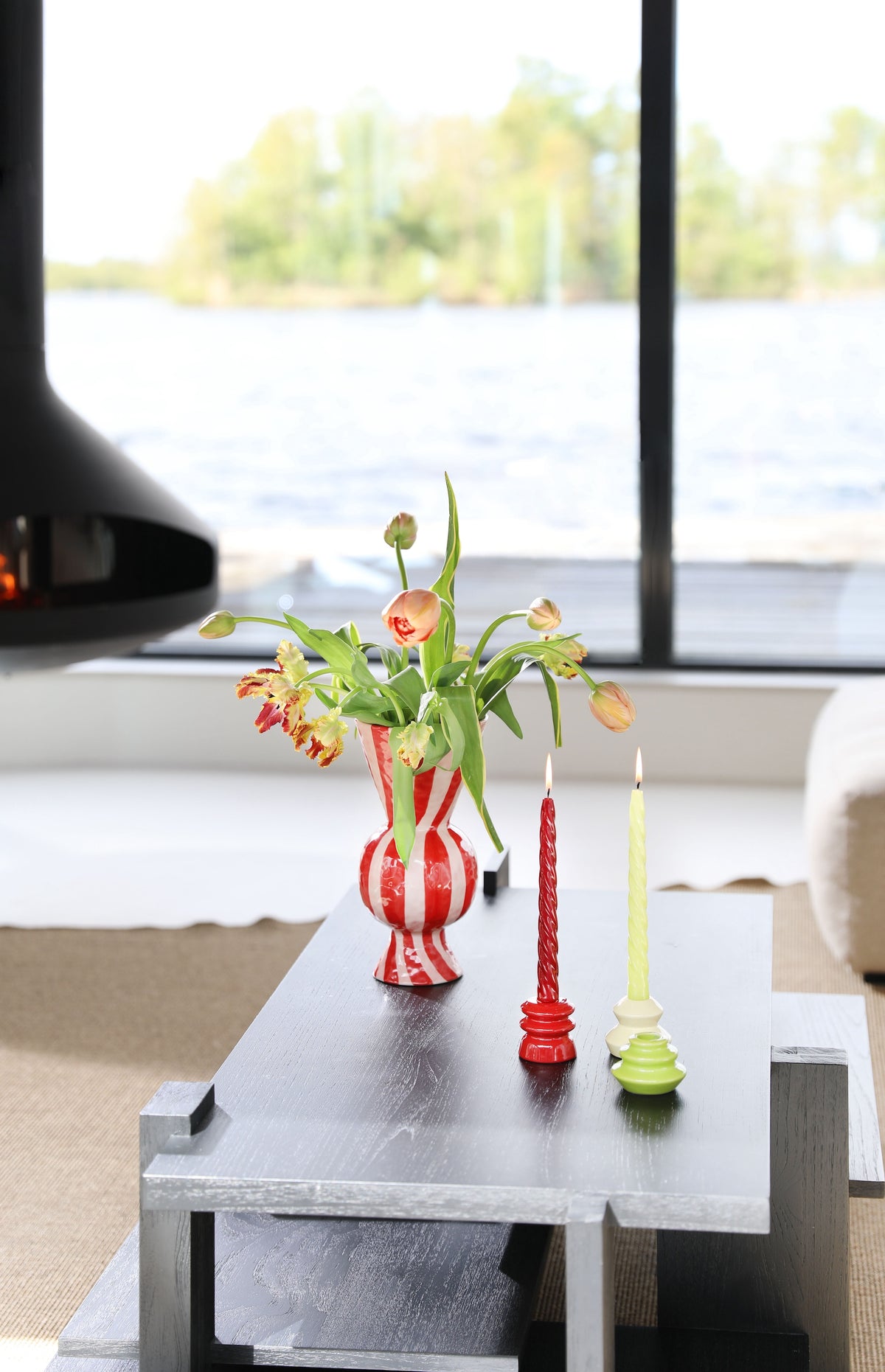 red twisted &klevering bravo candles styled on a coffee table with striped vase
