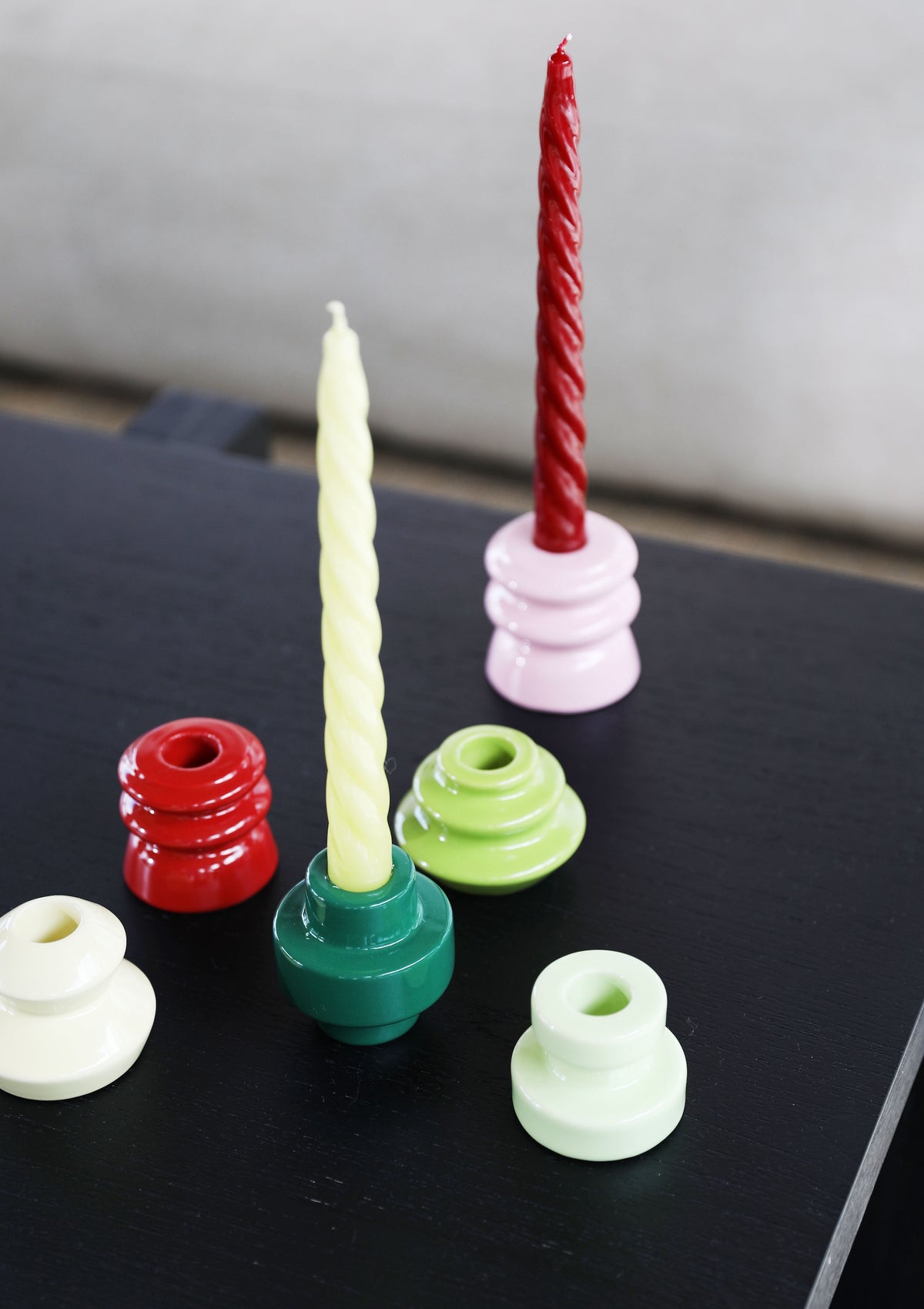red and cream twisted &k candles styled in colourful holders
