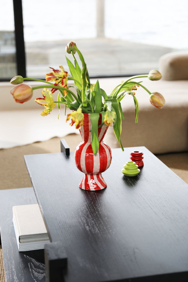 Decorative vase with flowers on a coffee table in a living room setting