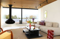 Modern living room with a large window view, beige sofa, and decorative items.