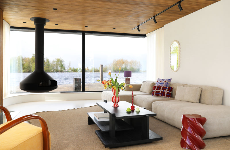 Modern living room with a large window view, beige sofa, and decorative items.