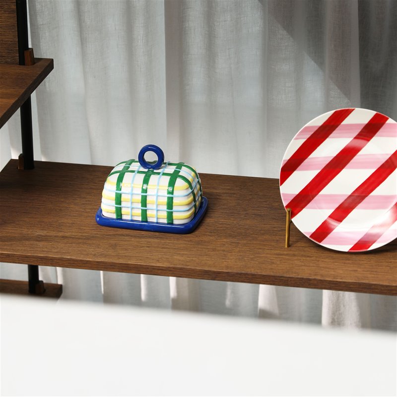 blue plaid ceramic butter dish displayed on wooden shelving
