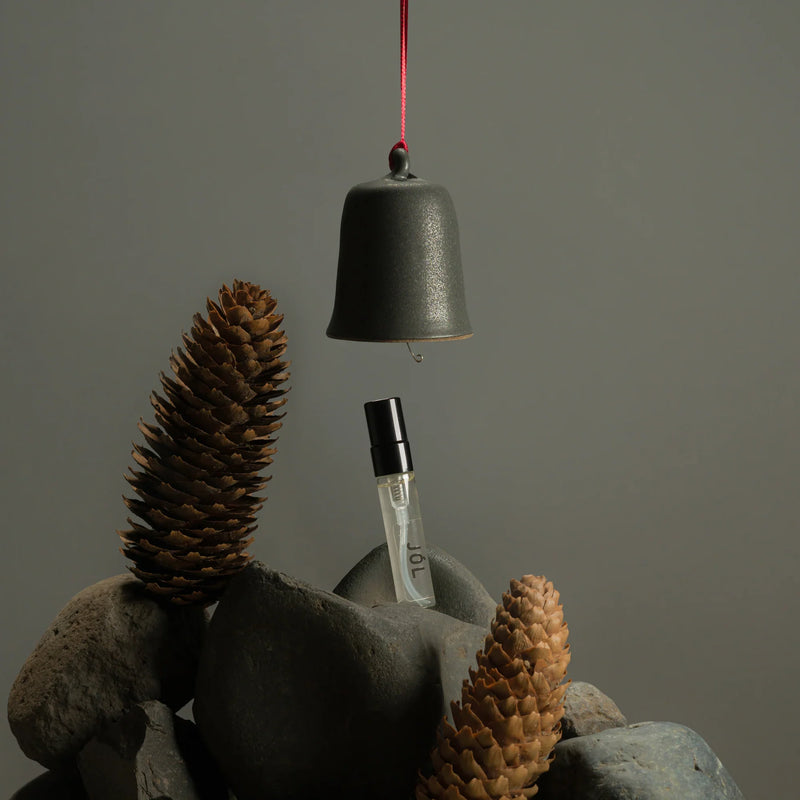 Fischersund JÓL holiday bell ornament with matching fragrance spray presented in earthy Icelandic-inspired setting