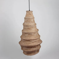 ceiling lamp shade of natural fibres in an almost wasp nest shape giving warm light and texture to the room it is in