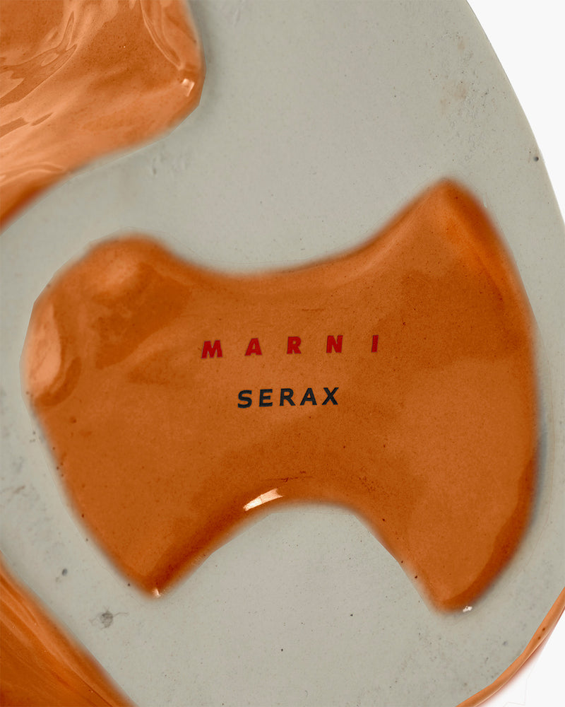 Close-up of a ceramic product with 'Marni Serax' branding on a gray background