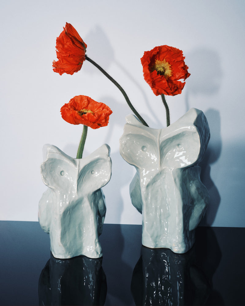 2 blueish owl shaped vases styled wth red poppies