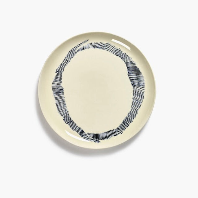 off white dinner plate with black stripes in a circular pattern creating the o of ottolenghi from serax on a dinner plate with a high shine and glaze level