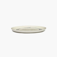 side view of the off white plate wiht black stripes from ottolenghi by serax feast range with a luxurious level of glaze