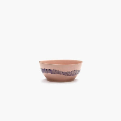 side view of a pink dessert bowl from ottolenghi with blue stripes running down the side in waves central any feast