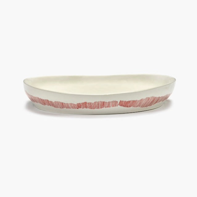 side view of the off white with red stripes deep serving dish perfect dinnerware with friends in the style of ottolenghi and showing quality of serax