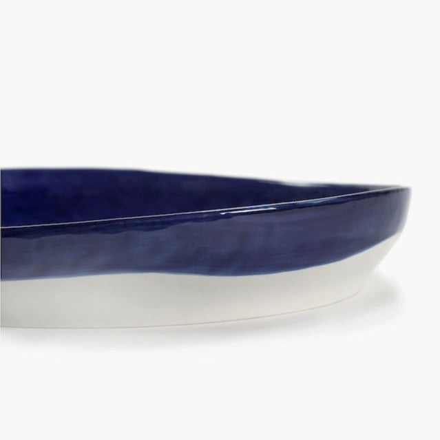 side view of the deep serving dish in teh style of ottolenghi and with the high quality of serax in a piece of dinnerware showing a deep strong glaze perfect for feasts with families and friends