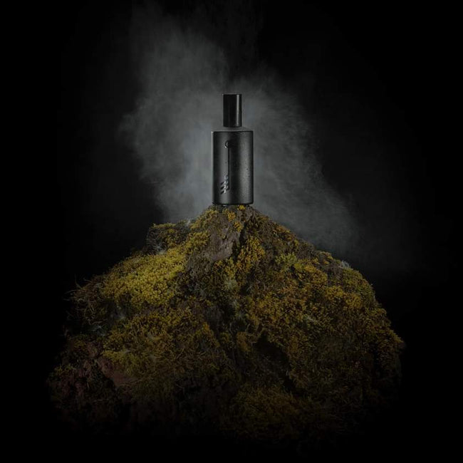 bottle of fragrance on a moutain top with mist of early mornig washing over it