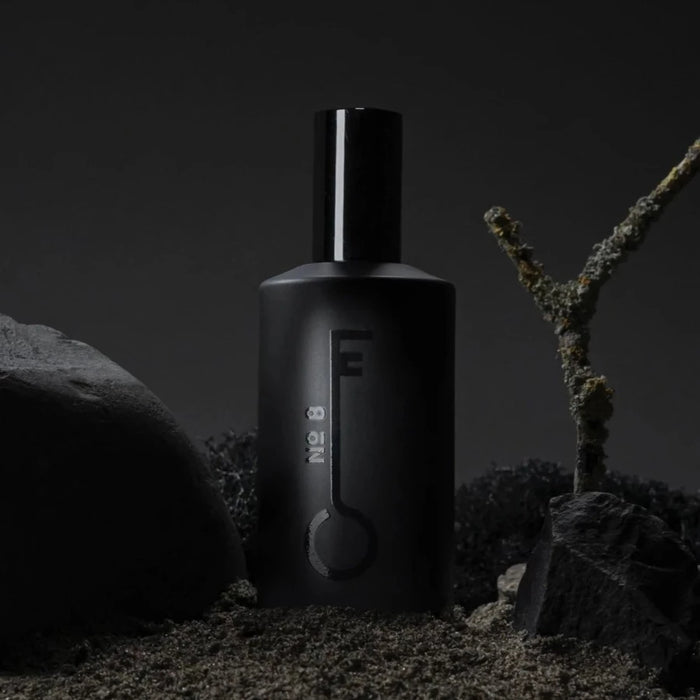 black bottle of fischersund number 8 that was handmade in iceland stood among black rocks and moss