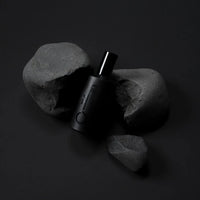 bottle of no.8 cologne by fischersund breaking free of a large black rock