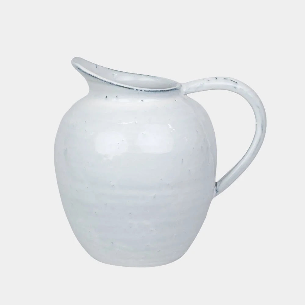 a bulbous fat jug in a generous white glaze wth marks from being handmade