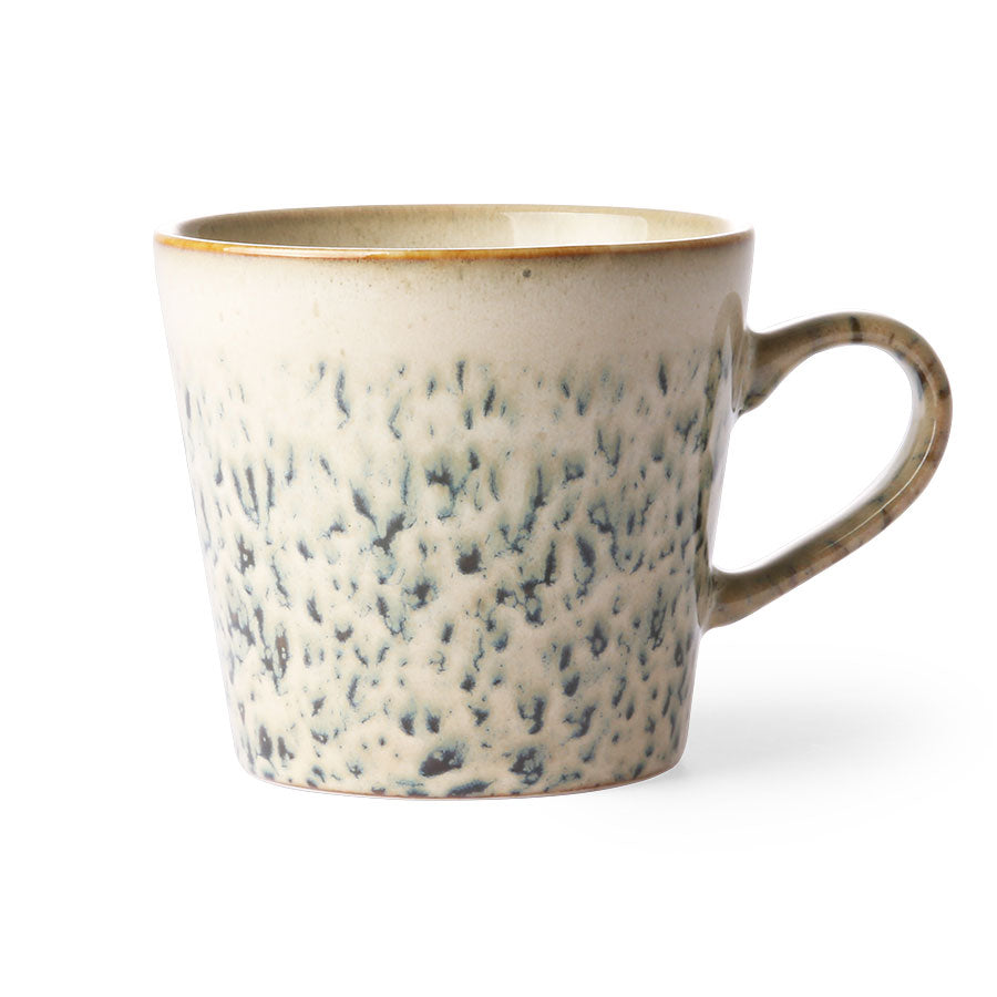 a handled mug from hkliving called hail looks like its raining and hailing heavily outside and it's sticking your window causing a streaky look to the outside world: streaks of creamy beige block the green of the foliage in your garden allowing apockets of blury visibility