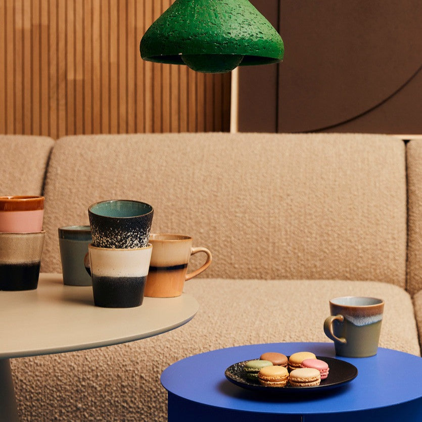 with a sofa, lighting and a side table set up with a drinks and snaks for either a lovely chat with friends or perhaps a night in watching movies with the colours now synominous with hkliving and the 70s collection