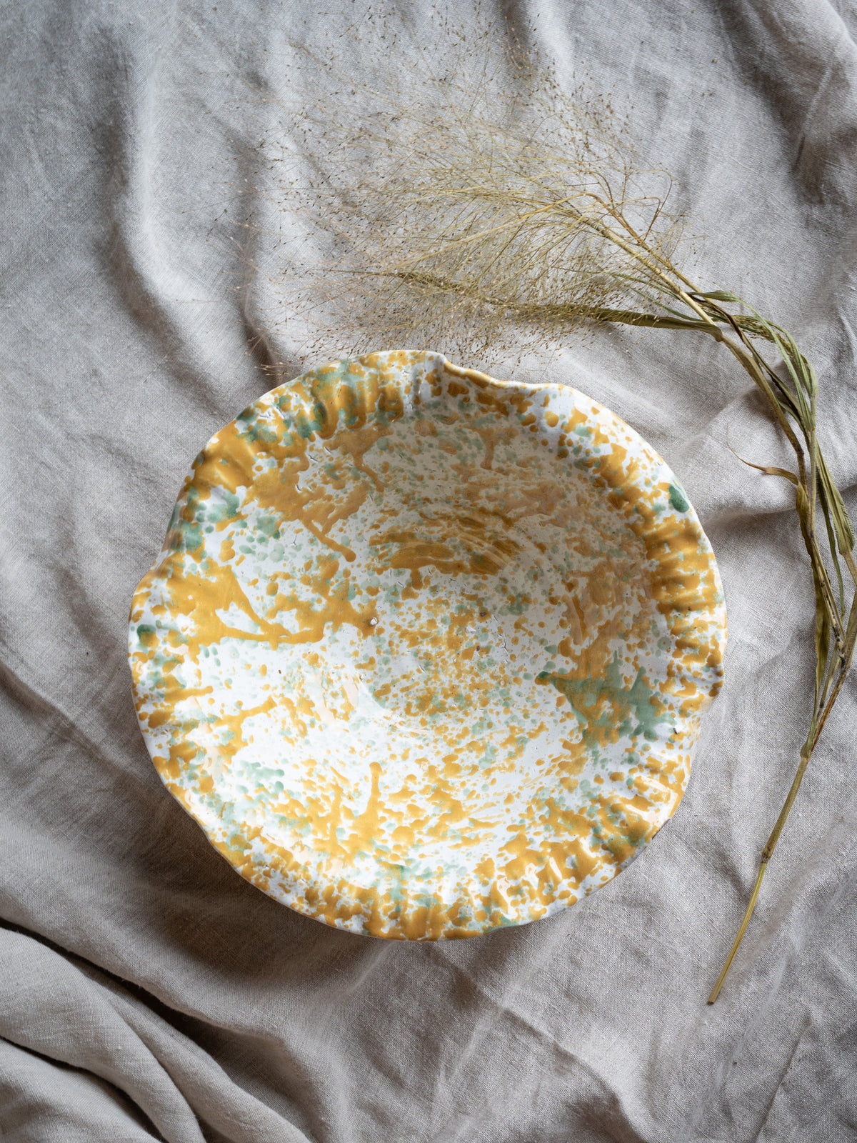 Large terracotta bowl with painterly yellow and green splatter