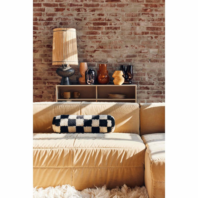 living room with a soft sofa and a bookcase behind with a lamp and a few vases including the brown shiny metalic vase