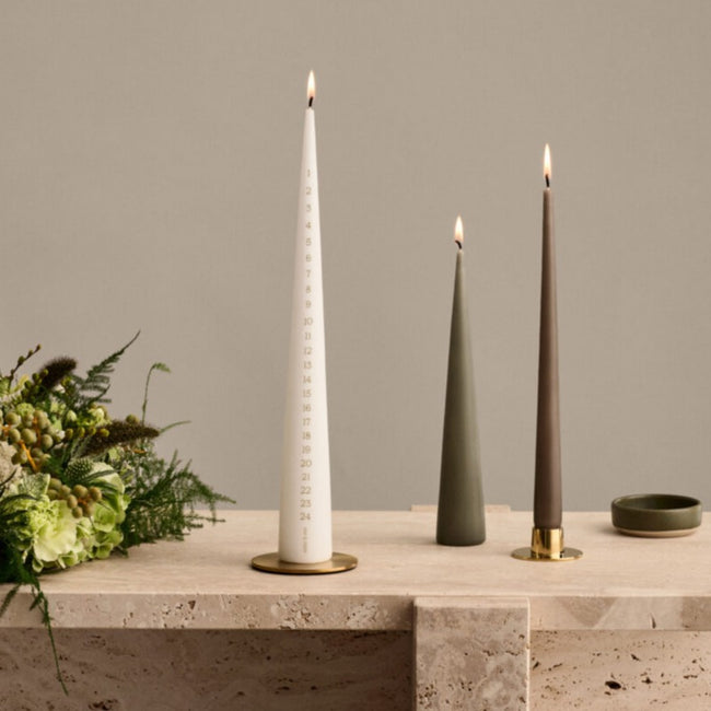 Display on cone shaped candles on candle plates apon a marble mantlepiece