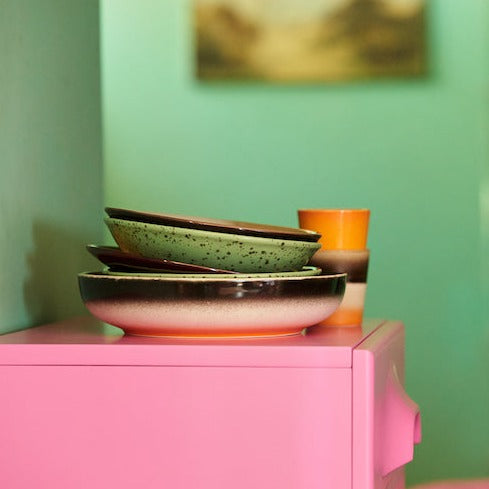 stack of 70s crockery from hkliving on a flurescent pink chest of drawers