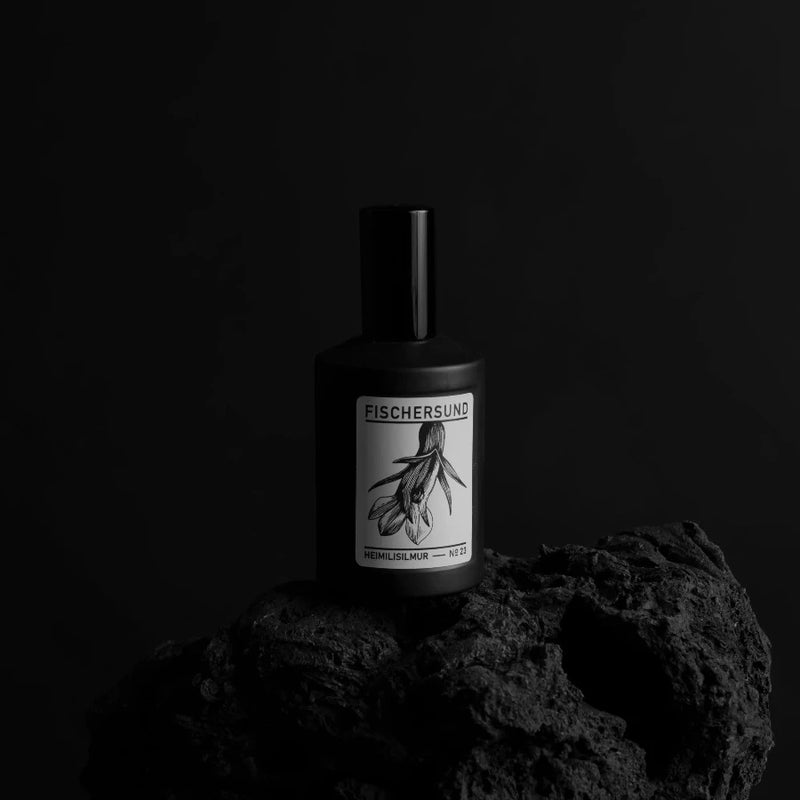 black bottle stood on black volcanic rock from near rejkjavik with handmade room fragrance from fischersund scent number 23