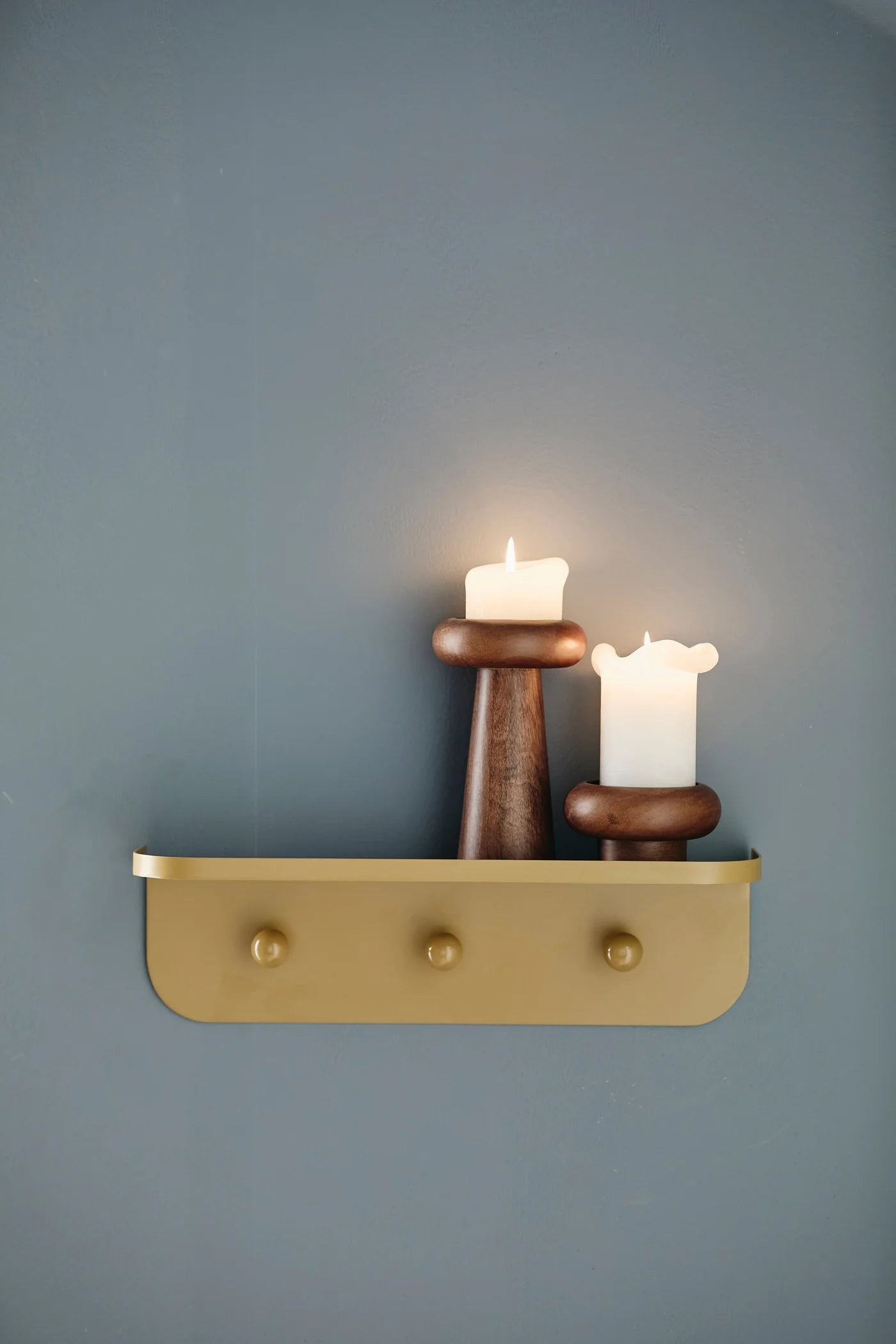 BAWE candle holders in mango wood by Nordal styled on a wall shelf with a candle and scarf