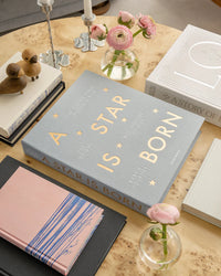 grey A Star Is Born baby album displayed among books and décor
