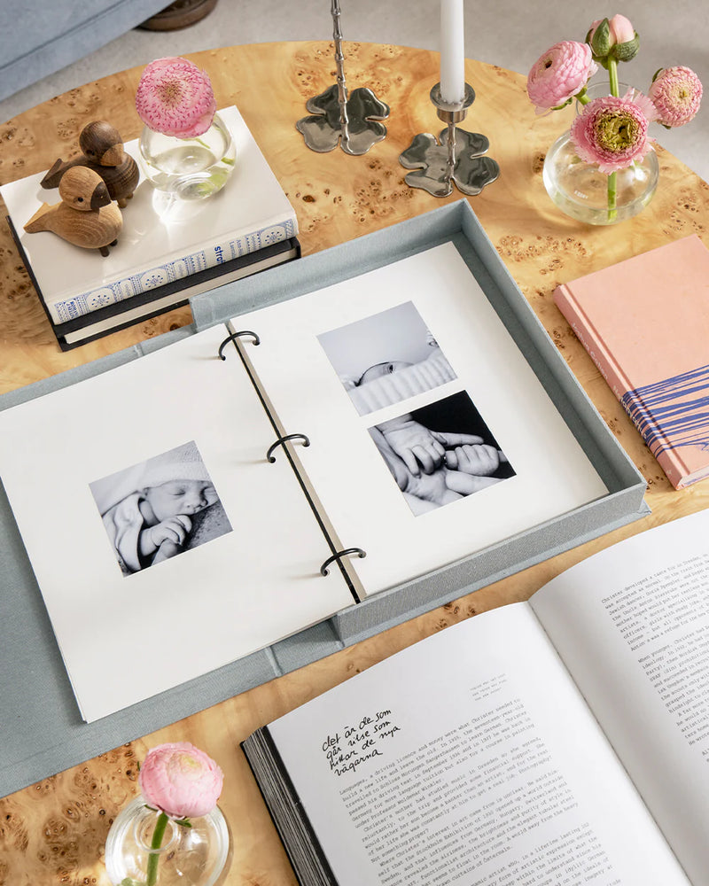 A Star Is Born baby album open on a table with printed baby photographs
