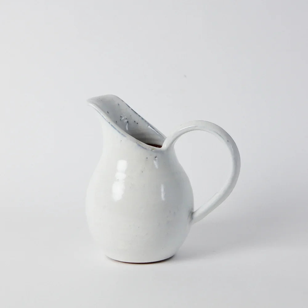 handmade clay jug with a generous white glaze and a tall long spout