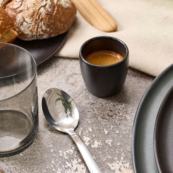 Minimalist black espresso cup in a table setting