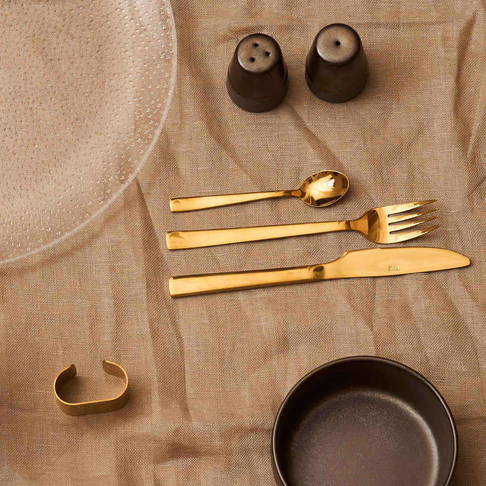 Metallic brown ceramic shakers with reactive glaze on a dining table
