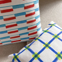 close-up of geometric clash cushion by &klevering with bold red and blue print
