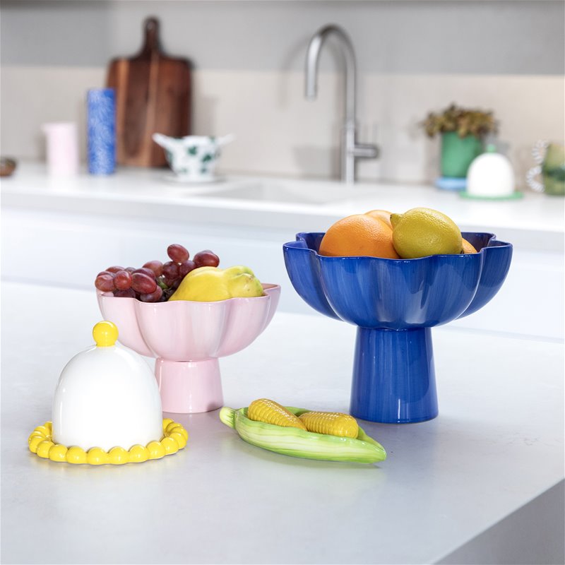 colourful pedestal fruit bowls by &k on a bright kitchen counter, styled with fresh fruit