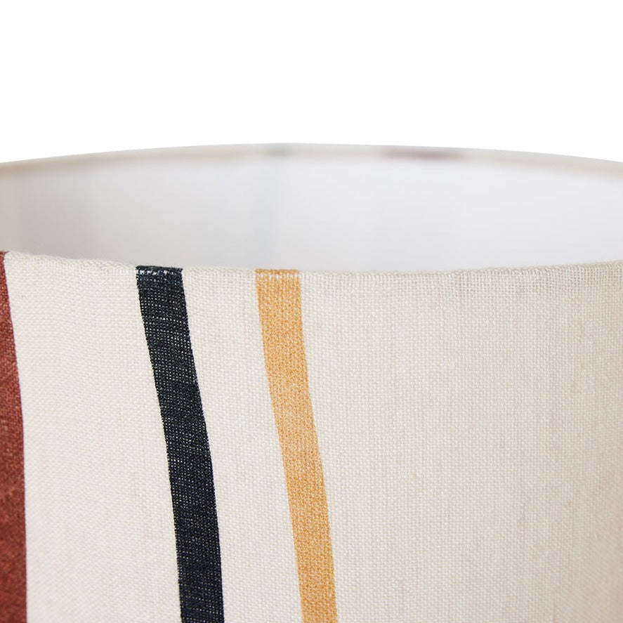 close up of the top of the lamp shade showing the slightly yellow, off white of the overall colour and the top of the curving stripes with red, black, and yellow