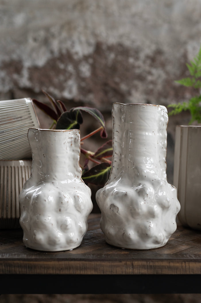 Sculptural ceramic vases styled with neutral tones and greenery