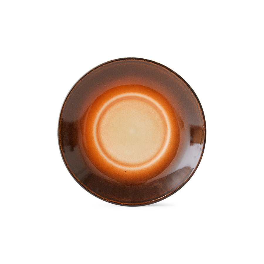 with a dot of white white cooling to a deep brown in circles across the face of this saucer from the design house hkliving