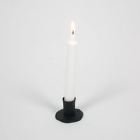 Adrian short black iron candle holder by Olsson & Jensen with a white taper candle