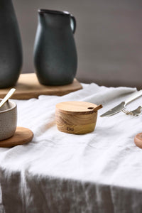 Small teak condiment bowl with lid styled in a table setting