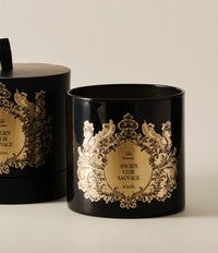 Black and gold decorative candle jar from the Ancien Cuir Sauvage collection, shown with matching gift box.