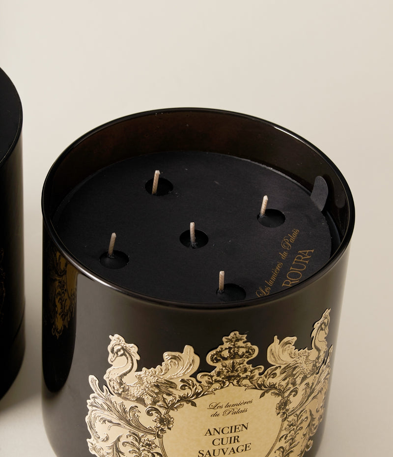 Close-up of the Ancien Cuir Sauvage candle showing multiple wicks inside the black glass vessel.
