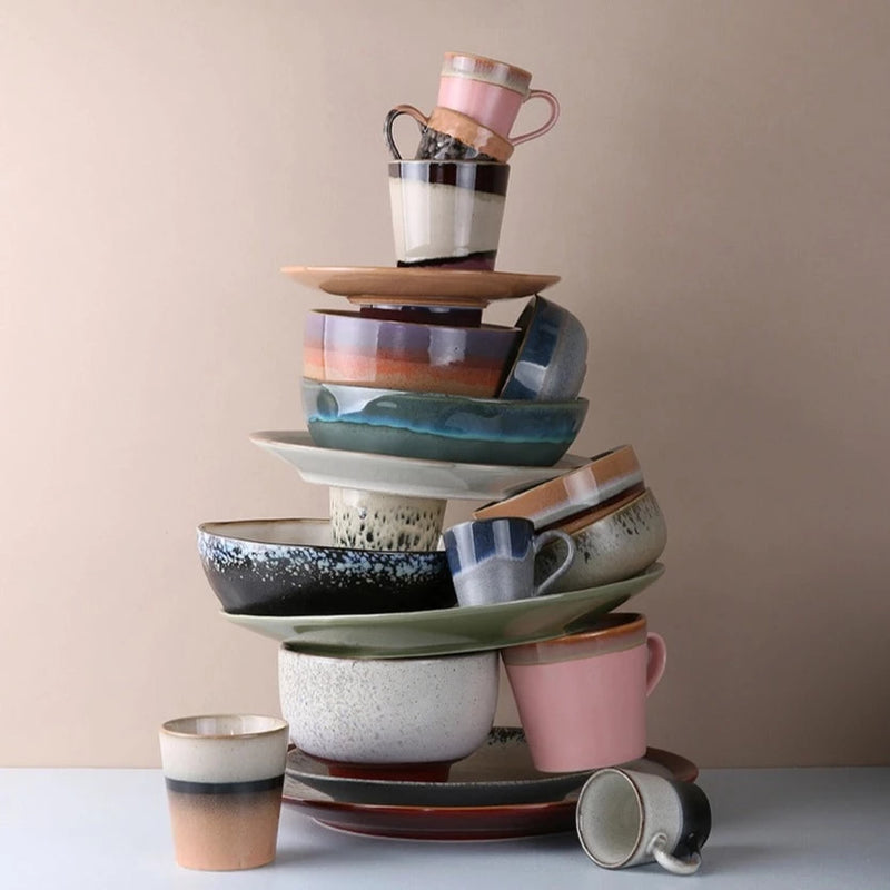 a stack of different pieces from hkliving's 70s collection from plates and pasta bowls to mugs and espresso cups in miriad colours : stacked like a tree, I've no idea how it's staying upright