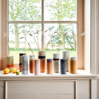 number of differently coloured 70s style hkliving vases stood on a windowsill from nordic style and design