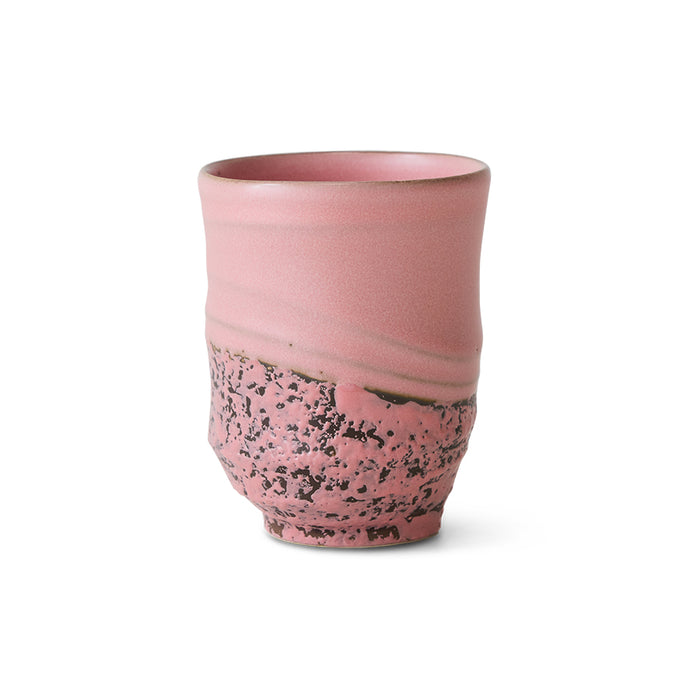 Hand-finished pink stoneware mug showing gentle curves and unique variations.
