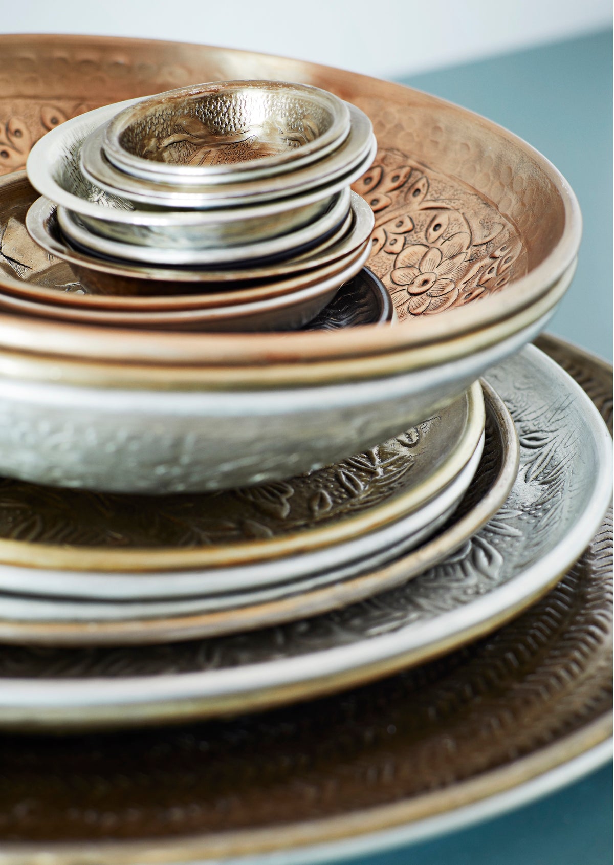 stack of hand-hammered brass and aluminium dishes in layered textured finish
