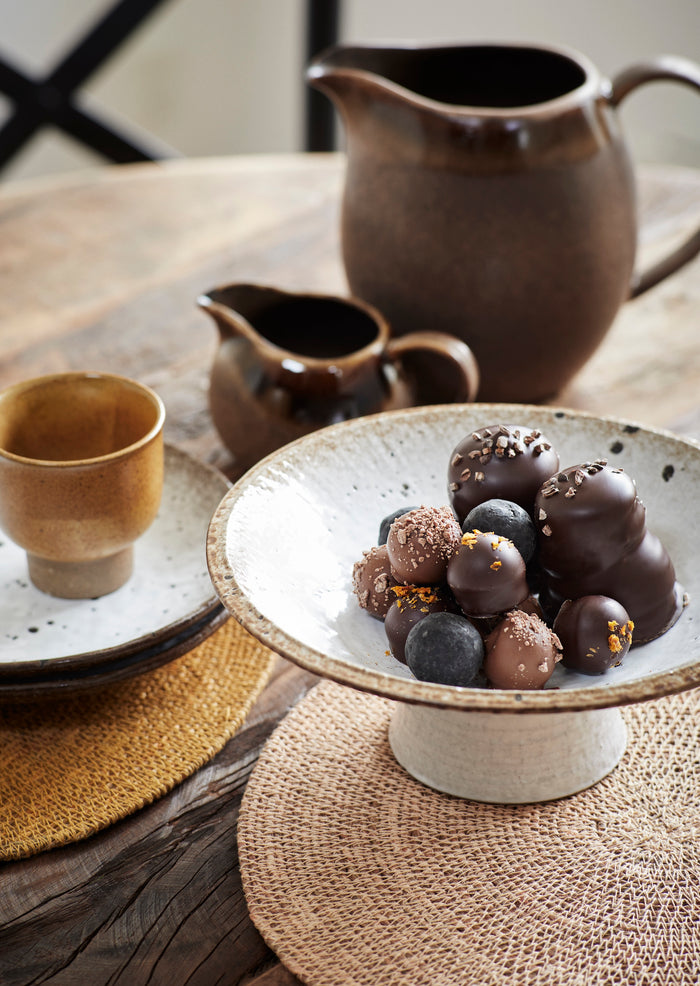 brown stoneware jugs in large and small sizes on a Nordic-inspired dining table