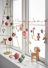 Scandinavian Christmas display with brass hanging bells and red-and-white string
