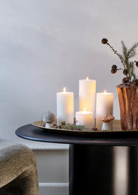 Candlelit table setting with candles and decorative tree trunk like vase